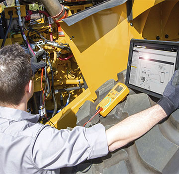 Cat Technician Reviewing Equipment with Laptop SIS 2.0