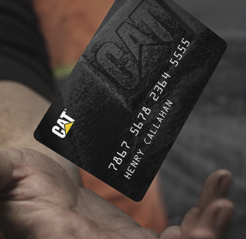 A mans dirty hand about to catch a Cat credit card